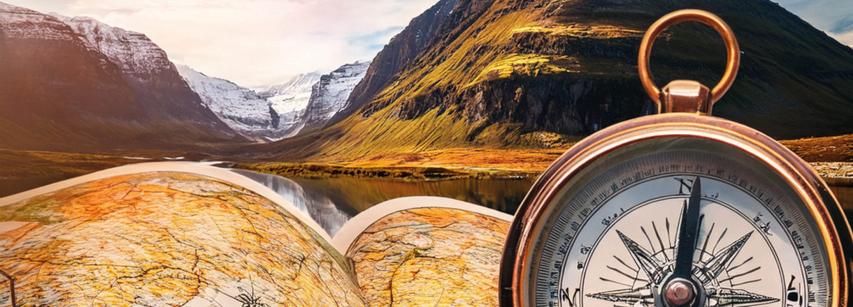 Bild av et kompass og et kart med et fjell i bakgrunn